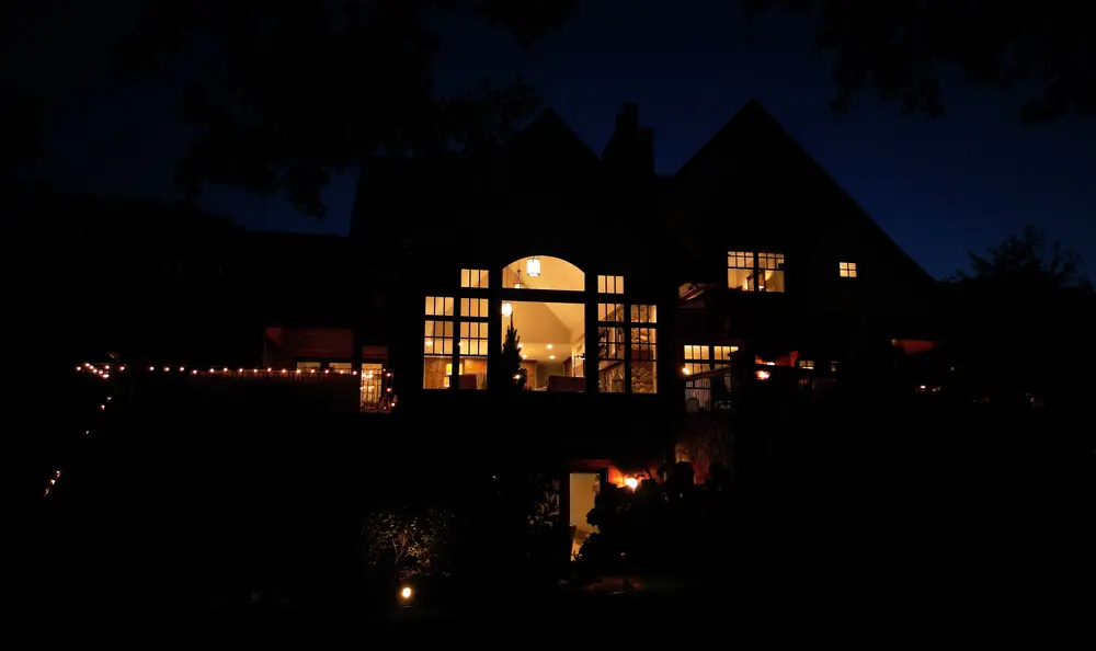 The home before renovation, photographed at night with warm light in the windows.